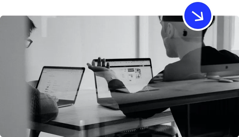 two guys talking in front of a compute